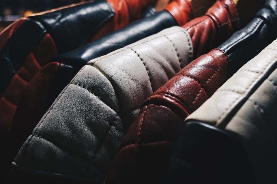 Row of quilted leather jackets in black, grey and oxblood on a rail